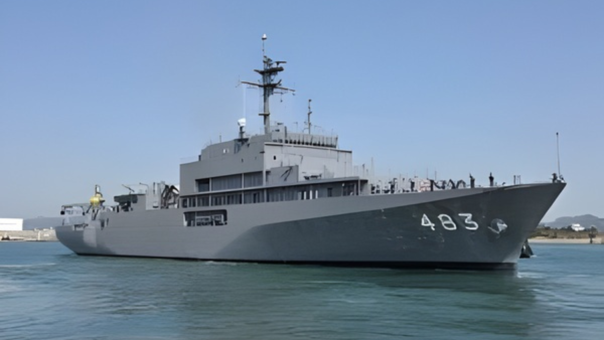 Naval support vessel marked 483 sailing in calm waters under clear sky