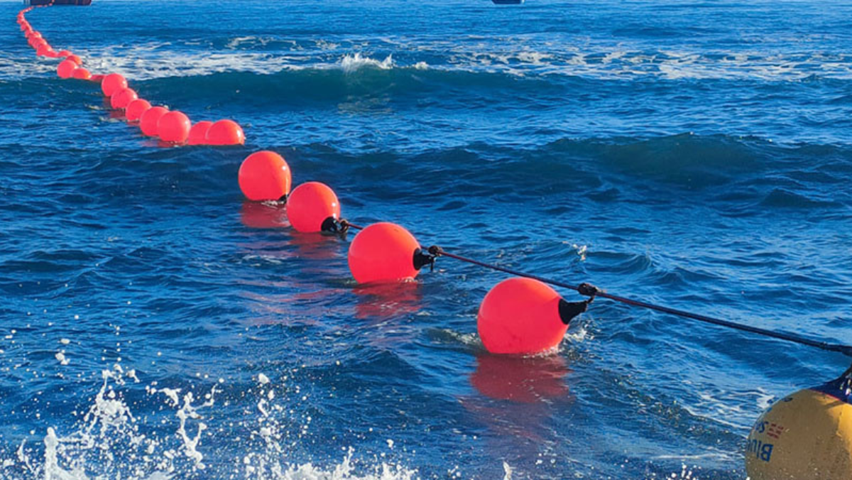 Red marker buoys outlining a subsea cable route in open water