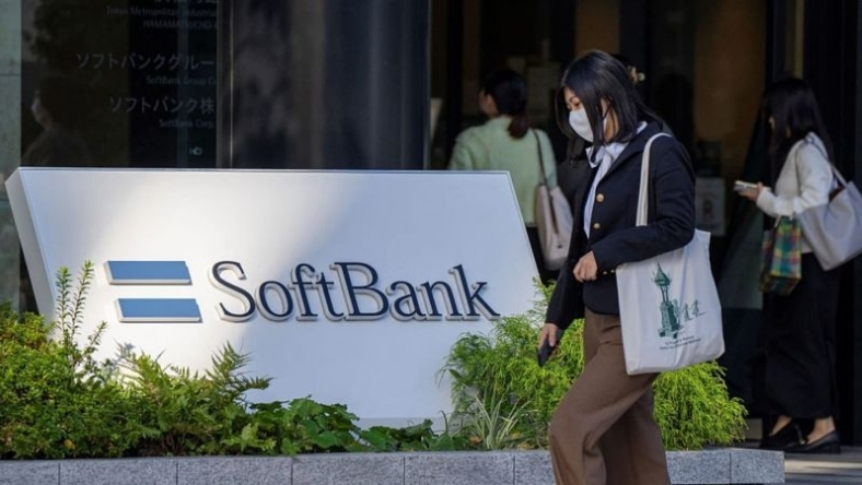 SoftBank logo sign outside office building entrance with people walking past